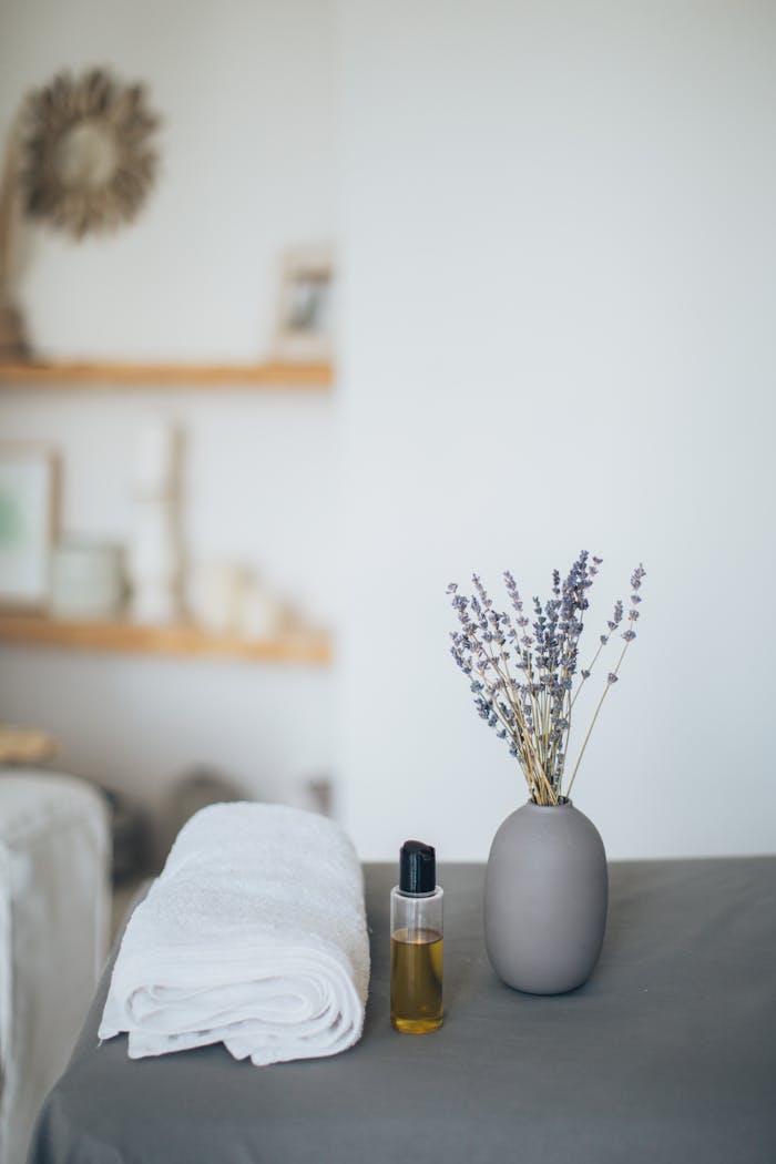 Relaxing spa scene featuring lavender, towel, and oil for a calming experience.